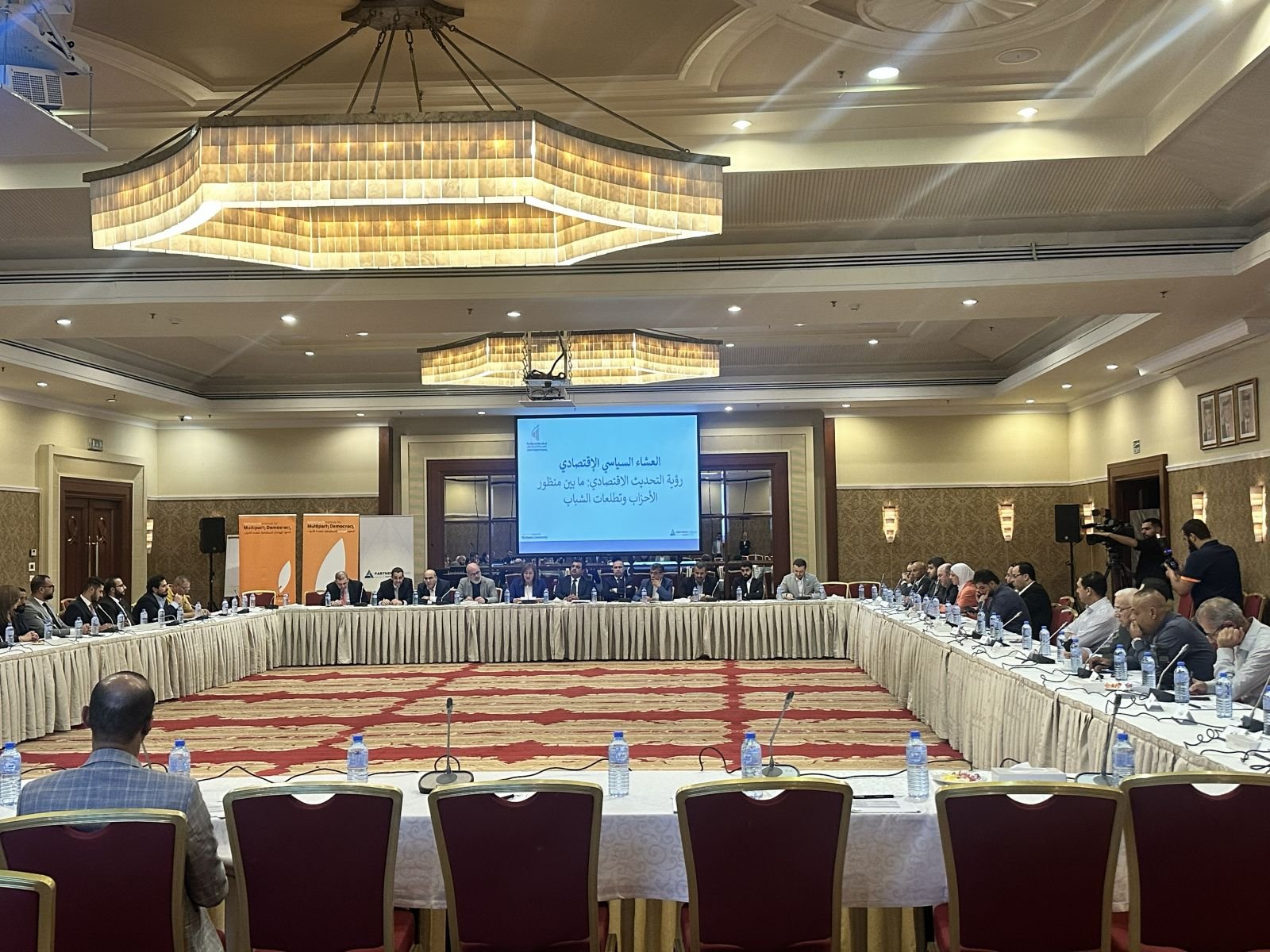 Delegates at a large U-shaped conference with interpretation