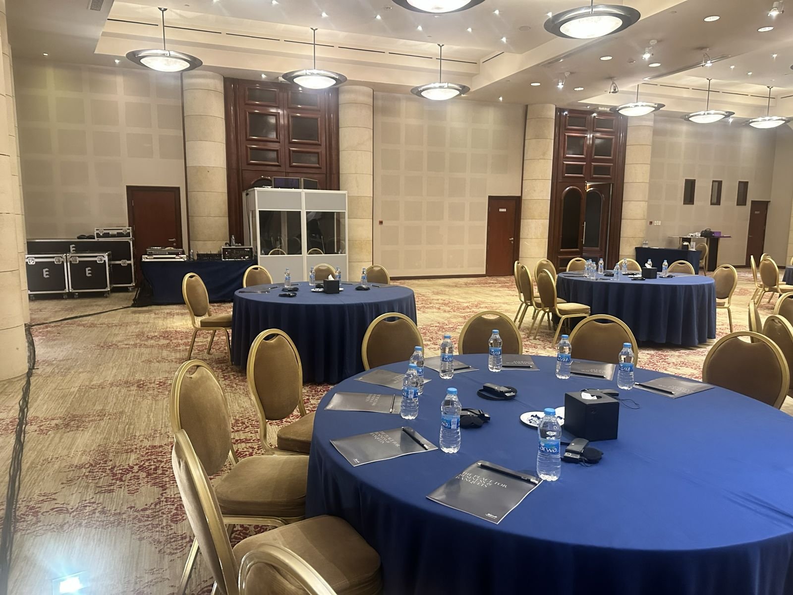 Conference tables set with materials and an interpretation booth
